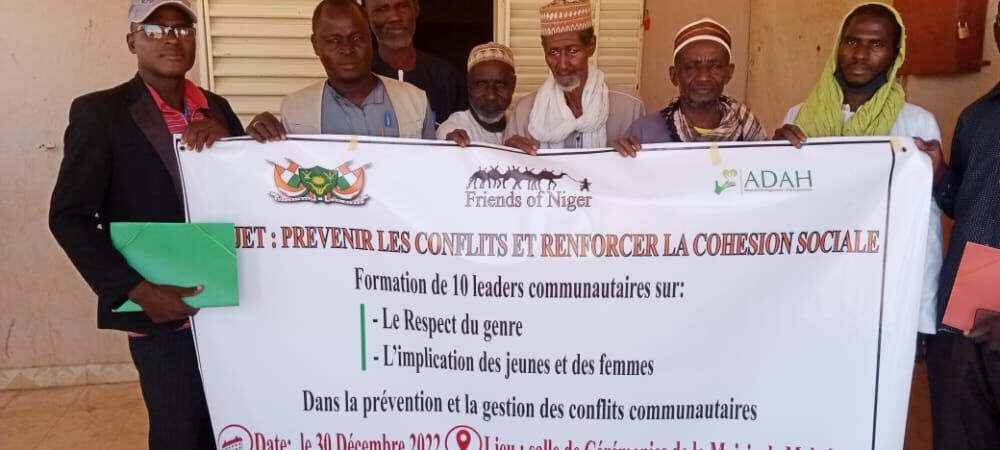 Leaders communautaires tenant la banderole de leur formation sur le genre